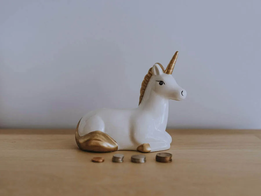 unicorn piggy bank with coin stacked in front of it budgeting for nurses
