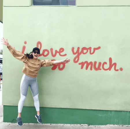 chelsea rofles nurse jumping in front of wall that says i love you so much
