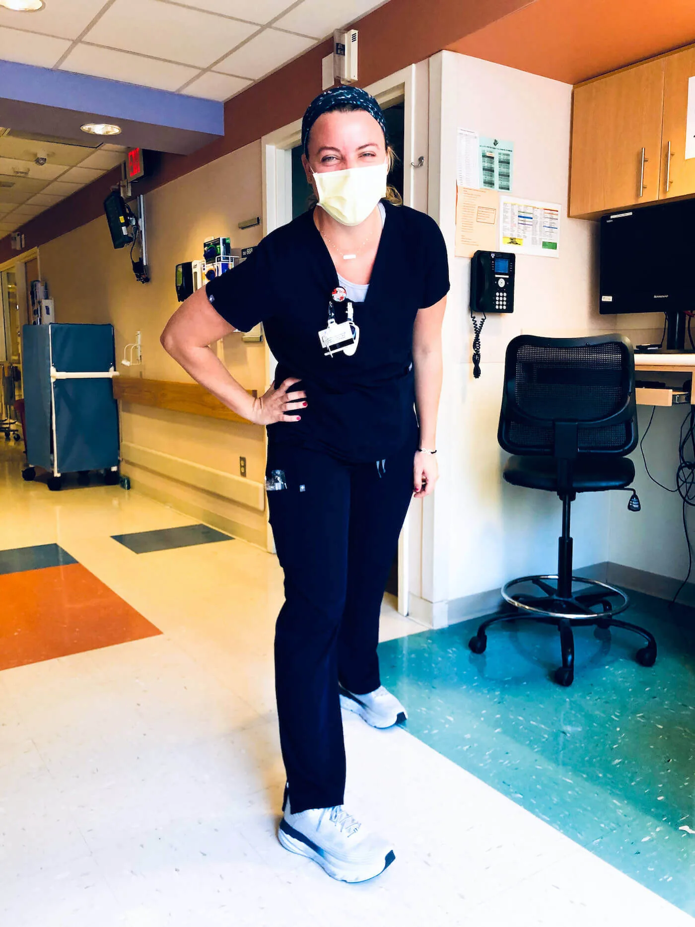 nurse courtney jones stands in hospital corridor posing with hoka nursing shoes