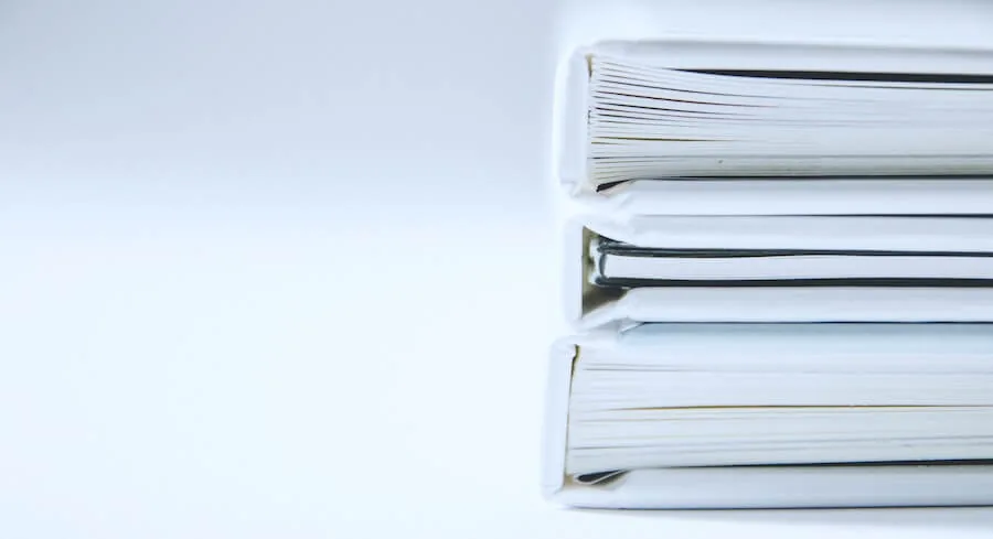 three large paper bindings are table in front of white background how to become an LPN documentation