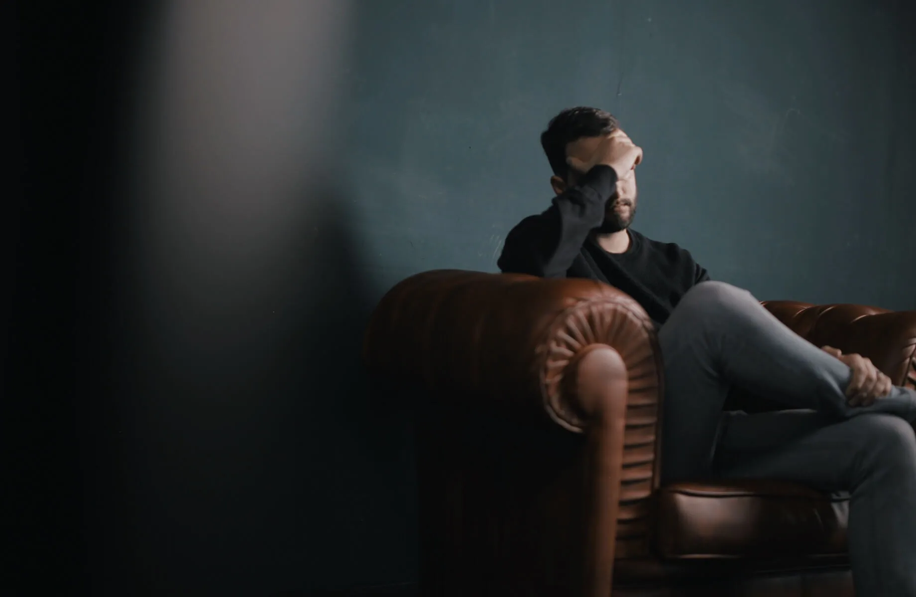 man in chair with hand over face male nurse ptsd