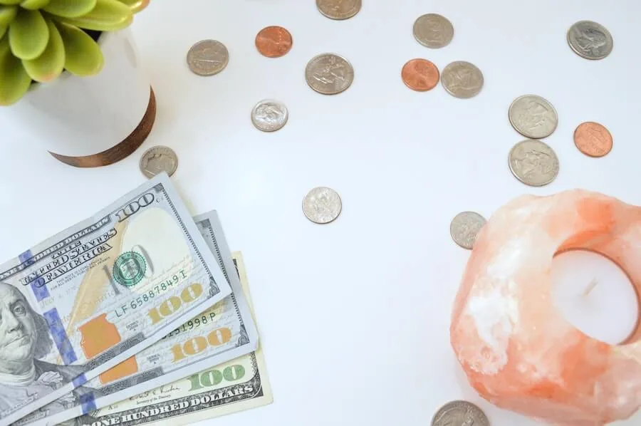 american money on white table next to candle and small plant top nursing blogs of 2020