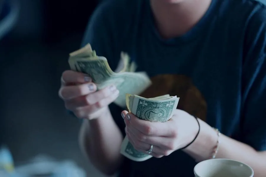 Woman flipping through dollar bills.