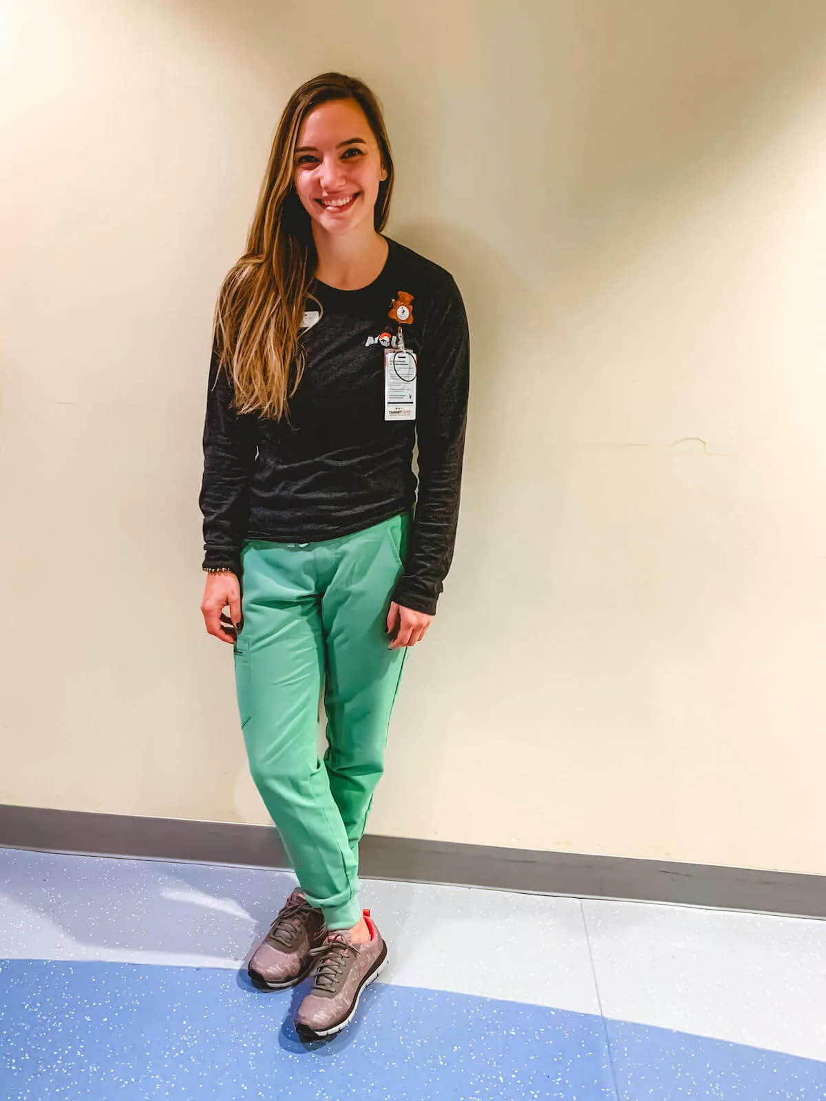 nurse ashley rn posing against wall showing off new skechers nursing shoes for nurses