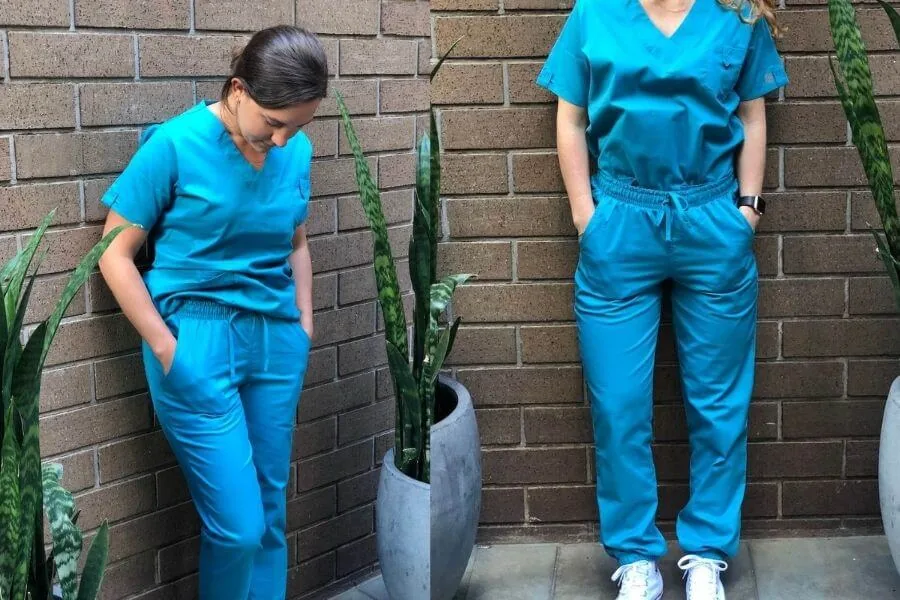 two nurses leaning against a wall modeling nursing scrubs uniform advantage scrubs