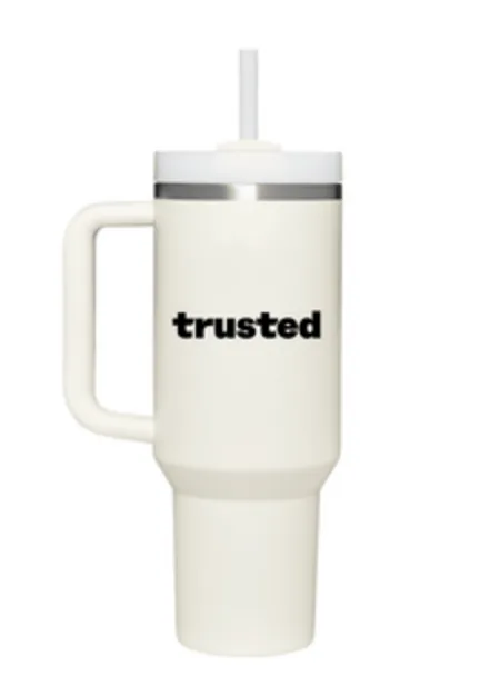 A 40oz Trusted Health Stanley Tumbler in cream color, featuring a sturdy handle and a clear reusable straw. The side of the tumbler proudly displays the word 'trusted' in bold black letters, symbolizing the reliability and community of Trusted Health professionals.