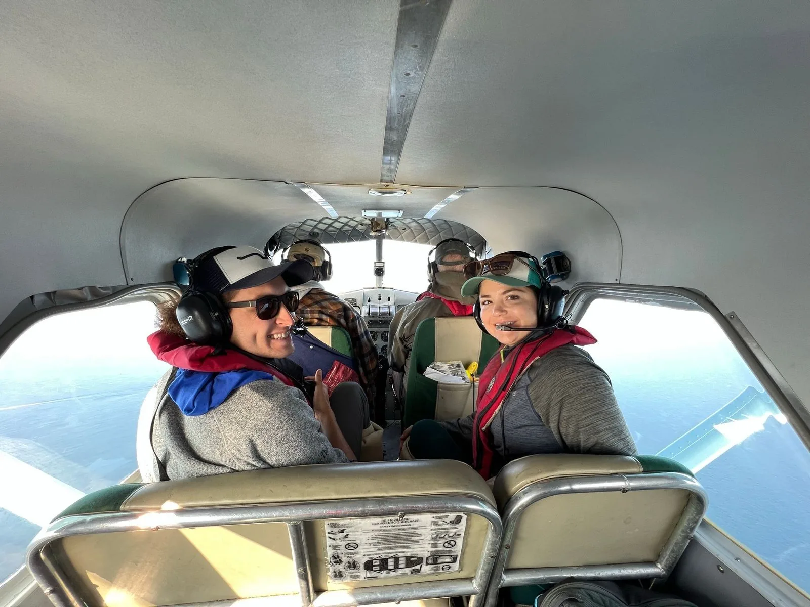 Author pictured with her husband in a small aircraft, smiles wide with anticipation as they embrace new experiences
