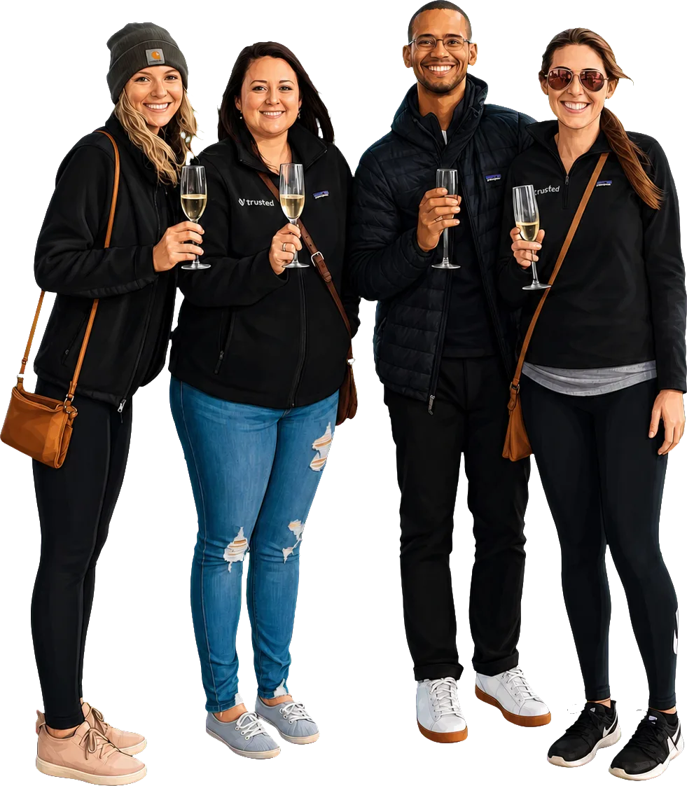 Four Trusted teammates in branded jackets raising a toast